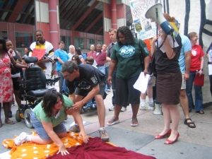 In this photo, members of the community perform a scene of street theater, portraying what life would be life without personal assistant services
