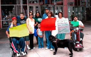 photograph of DRACH members holding signs outside of the Thompson Center. This picuture was taken at a rally to protest against cuts to Home Services
